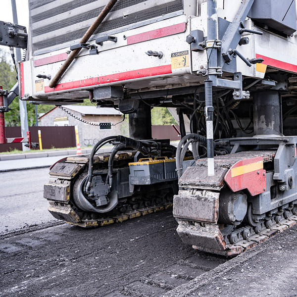 self-propelled tracked road milling cutter for removing old asphalt pavement during road repairs. Large Road cold milling machine removes the old asphalt and loading into a dump truck.